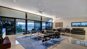 Una sala moderna con un gran ventanal, una chimenea y un comedor.