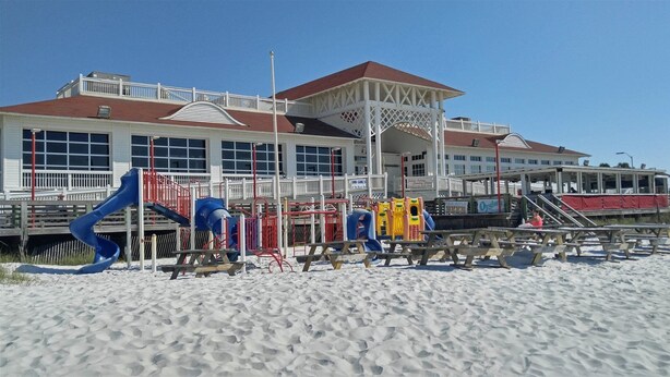 A beachside building with a playground, picnic tables, and a covered area. - Beachy Keen #501 Free Beach Svc 2 Chairs and Umbrella 2Bd 2Bath 1st Fl (Destin)