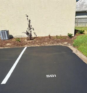 Un parcheggio con una linea bianca che delimita lo spazio e il numero 501 dipinto sull'asfalto.