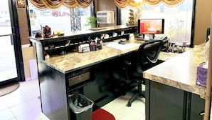 A small, well-lit office with a desk, chair, computer, and various office supplies. - Relax Inn (Vinita)