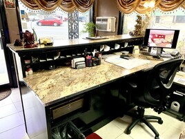 A hotel reception desk with a computer monitor, a telephone, and various office supplies.