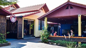 A restaurant with a sign reading "Moo Monkey Luang Prabang" and a covered outdoor seating area. - Mad Monkey Luang Prabang (Luang Prabang)