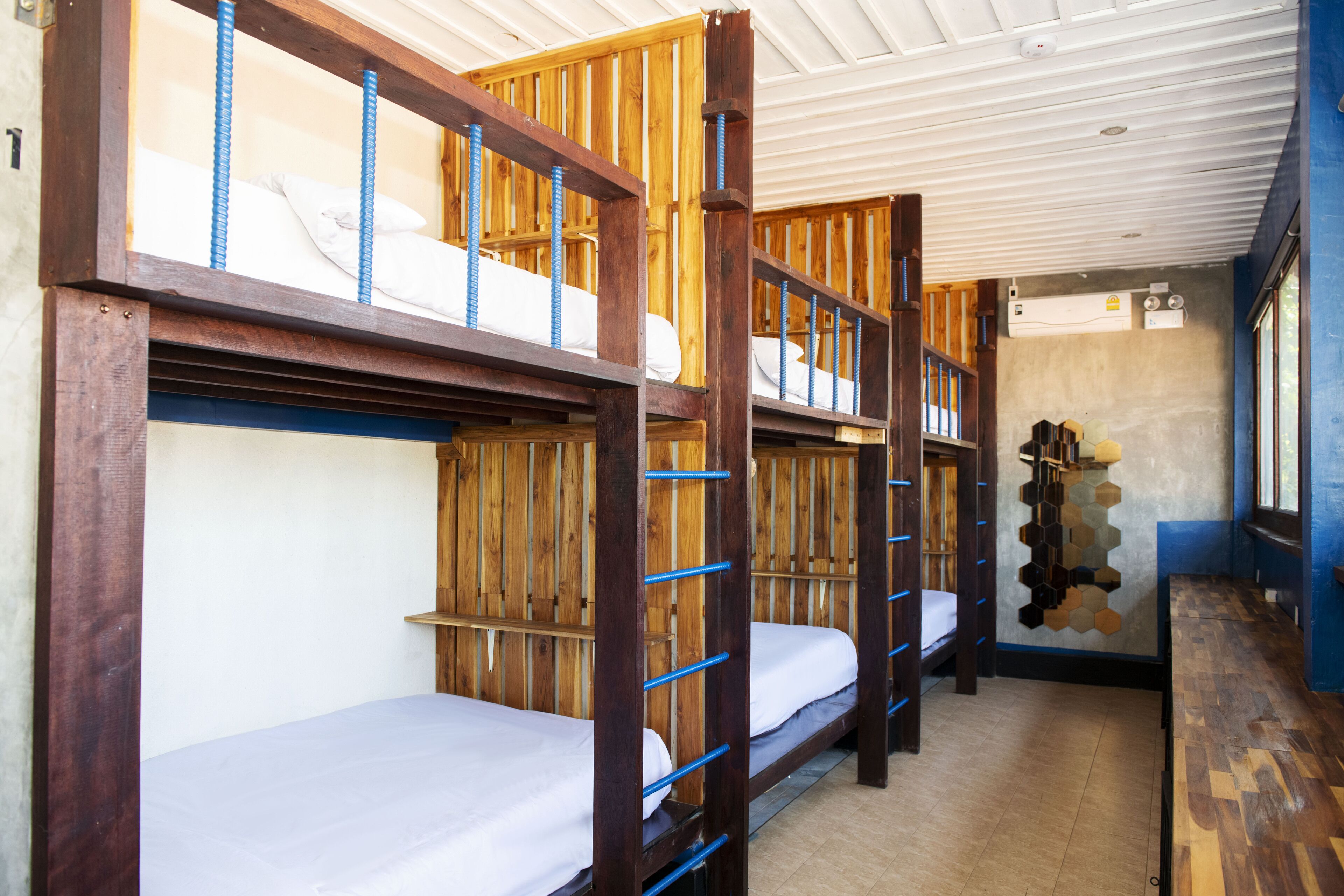 Habitación tipo dormitorio con literas y un adorno en forma hexagonal en la pared.