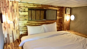 A wooden-paneled bedroom with a bed, a window, and a wall-mounted light fixture. - Mad Monkey Luang Prabang (Luang Prabang)