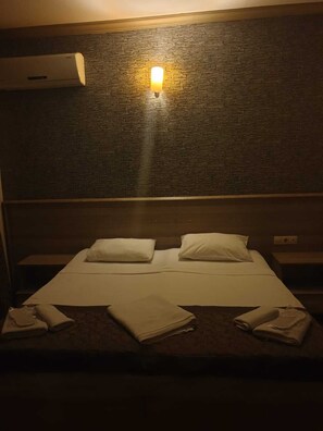A hotel room with a bed, pillows, a wall-mounted air conditioner, and a wall-mounted light fixture. - Zeytin Butik Otel (Istanbul)