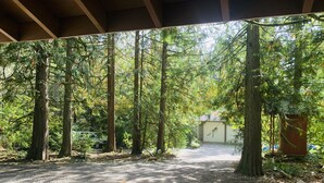 A covered outdoor area with a gravel path leading to a building. - Luxury Cottage in the Woods with Movie Theater!  (Auburn)