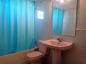A bathroom with a toilet, sink, and a shower curtain. - La Marina I 4º Solo Familias! (Xeraco Playa)