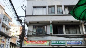 A multi-story building with commercial establishments on the ground floor, including a bakery and an embroidery shop. - Green House Lodge (Kathmandu)
