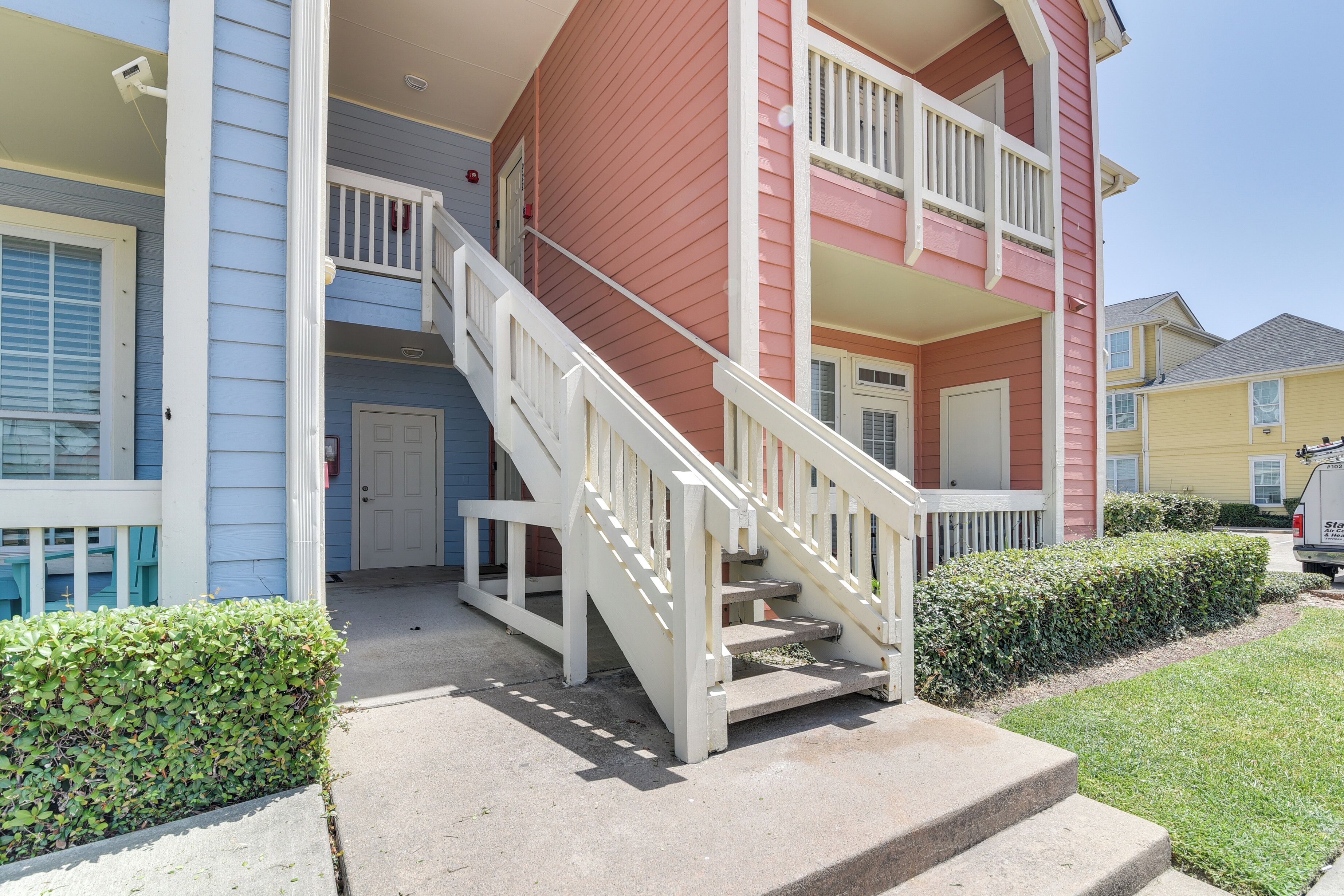 A two-story building with a white staircase leading to a front door.