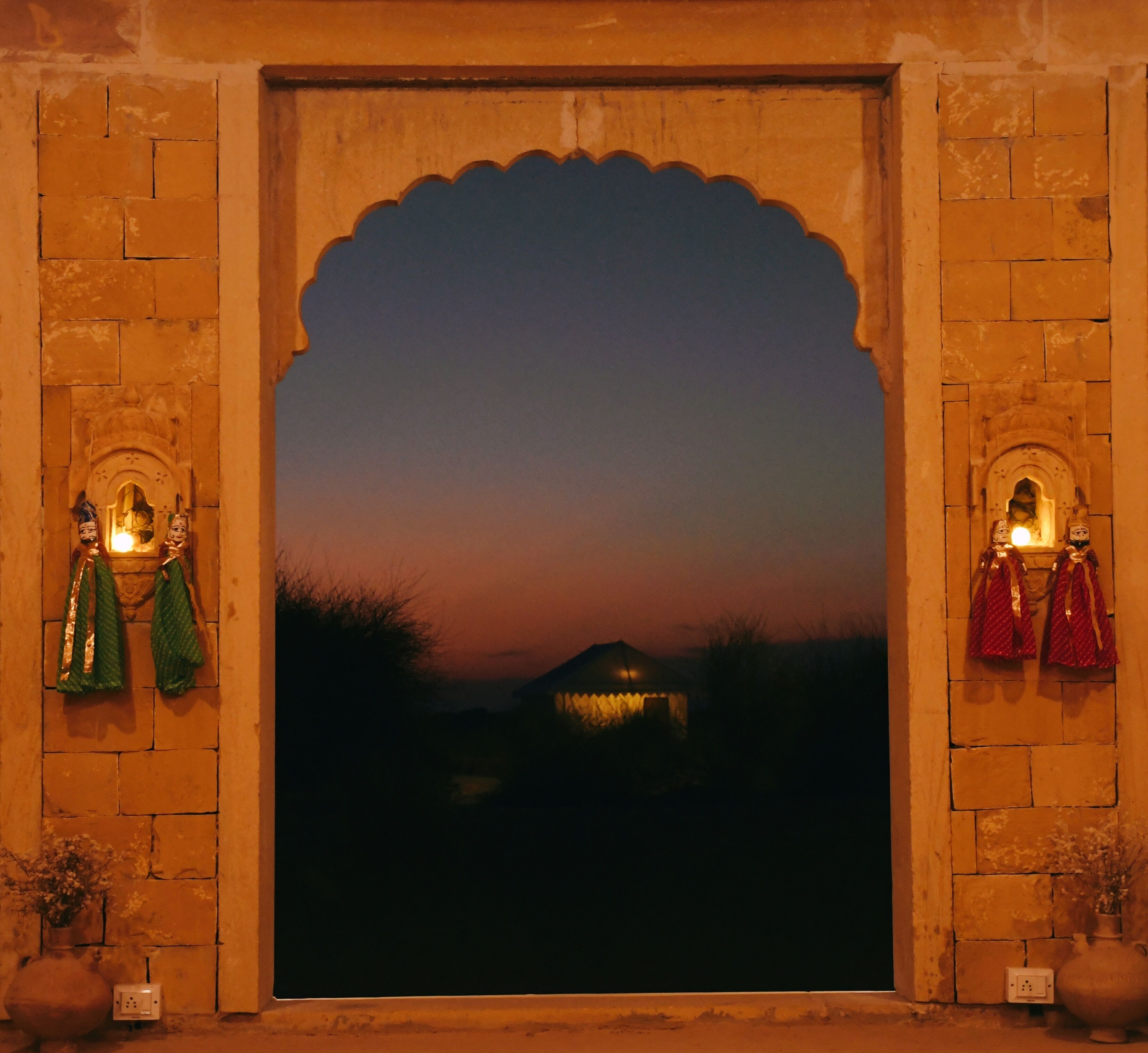 Un arco de entrada tradicional con vistas a un paisaje al atardecer.