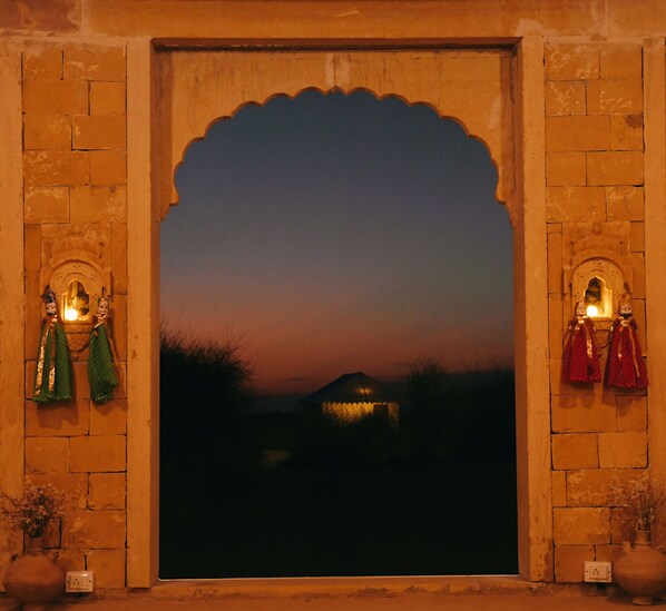 A traditional arched doorway with a view of a sunset landscape.