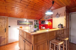Ein Holzinterieur mit Küchenbereich, einer Bar, einer Mikrowelle und einer Wanduhr.