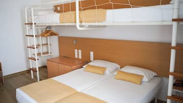 A bunk bed room with a wooden headboard, a wooden nightstand, and a wardrobe.