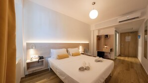 A modern hotel room with a large bed, bedside tables, a desk, and a chair. - Sissy (Kamena Vourla)