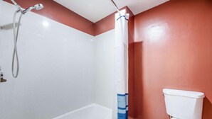 Un baño con bañera, ducha e inodoro.