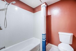 Une salle de bain avec une baignoire, une douche et des toilettes.
