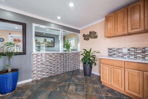 Una cocina con salpicadero de azulejos, armarios de madera y plantas en macetas.