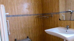 A bathroom with a shower, a sink, and a mirror.