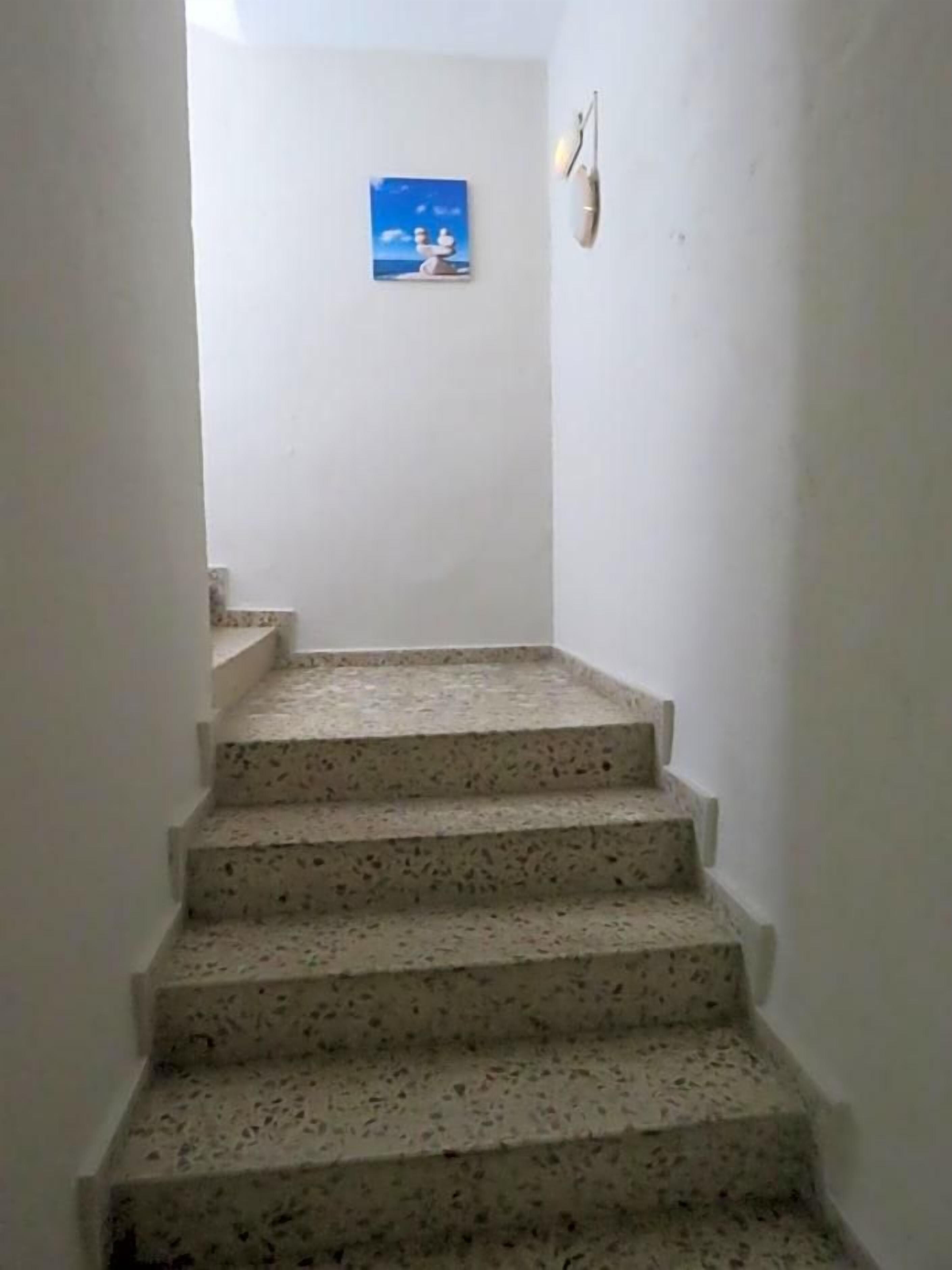 Una escalera estrecha con escalones moteados que lleva a una plataforma.