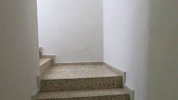 Una escalera estrecha con escalones moteados que lleva a una plataforma.