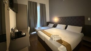 Une chambre d’hôtel avec un grand lit, un bureau, une chaise et un téléviseur.