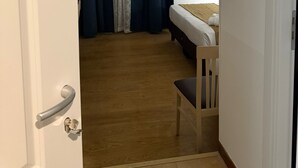 Une pièce avec un lit, une chaise et une porte.