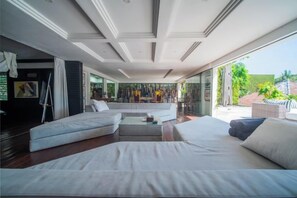 Ein modernes Wohnzimmer mit einer Couch, einem Couchtisch und Blick ins Freie.