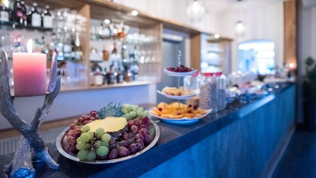 Un buffet proposant une variété de plats, une bougie allumée et un arbre décoratif.