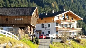 A hotel with a wooden facade and a sign reading "Zimmer". - Alpenhof Grafleiten (Zell am See)