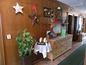 A room with a wooden wall, a star decoration, a plant, a table with candles, and a dresser. - Alpenhof Grafleiten (Zell am See)