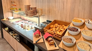 A buffet area with various food items, including breads, pastries, and fruits. - Familienhotel Kleinwalsertal (Mittelberg)