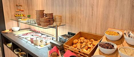 A buffet setup with various food items and serving utensils.