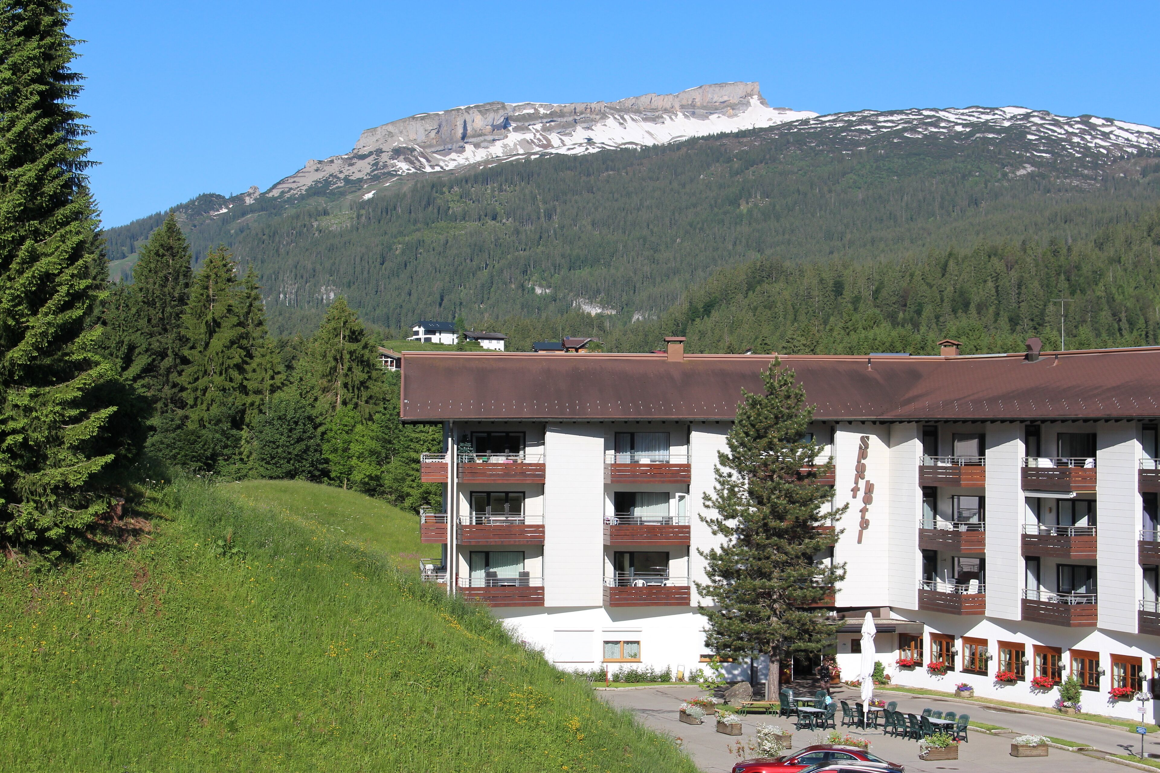 Un hôtel doté de nombreux balcons, d’un parking et situé dans un cadre montagneux.