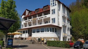 A multi-story building with a restaurant on the ground floor, a cafe on the second floor, and a parking area in front. - Am Edersee (Edertal)