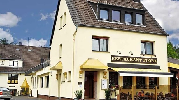 A two-story building with a sign reading "RESTAURANT FLORA". - Flora (Dormagen)