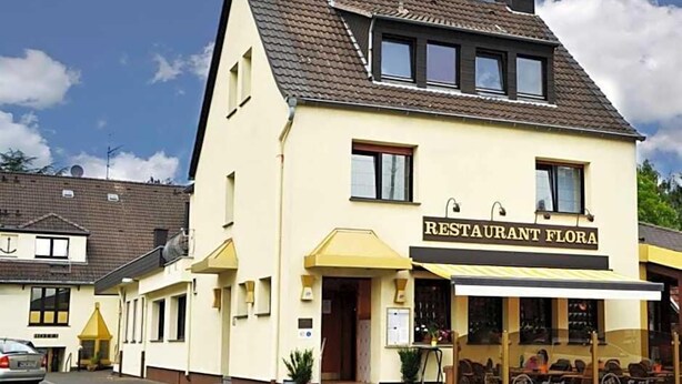 A two-story building with a sign reading "RESTAURANT FLORA". - Flora (Dormagen)