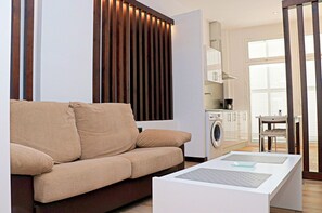 Relax in this stylish living room with a sofa, coffee table, and washing machine.