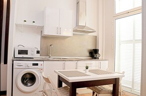 Enjoy cooking in this kitchen with a washing machine, coffee maker, and microwave.