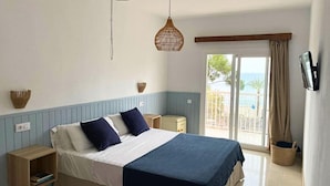 A bedroom with a bed, bedside tables, a TV, and a view of the outdoors. - Ca sa Madona (Calvià)