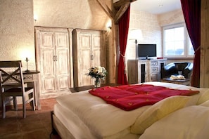 A bedroom with a bed, a desk, a television, and a window. - Binzhotel Landhaus Waechter (Binz)