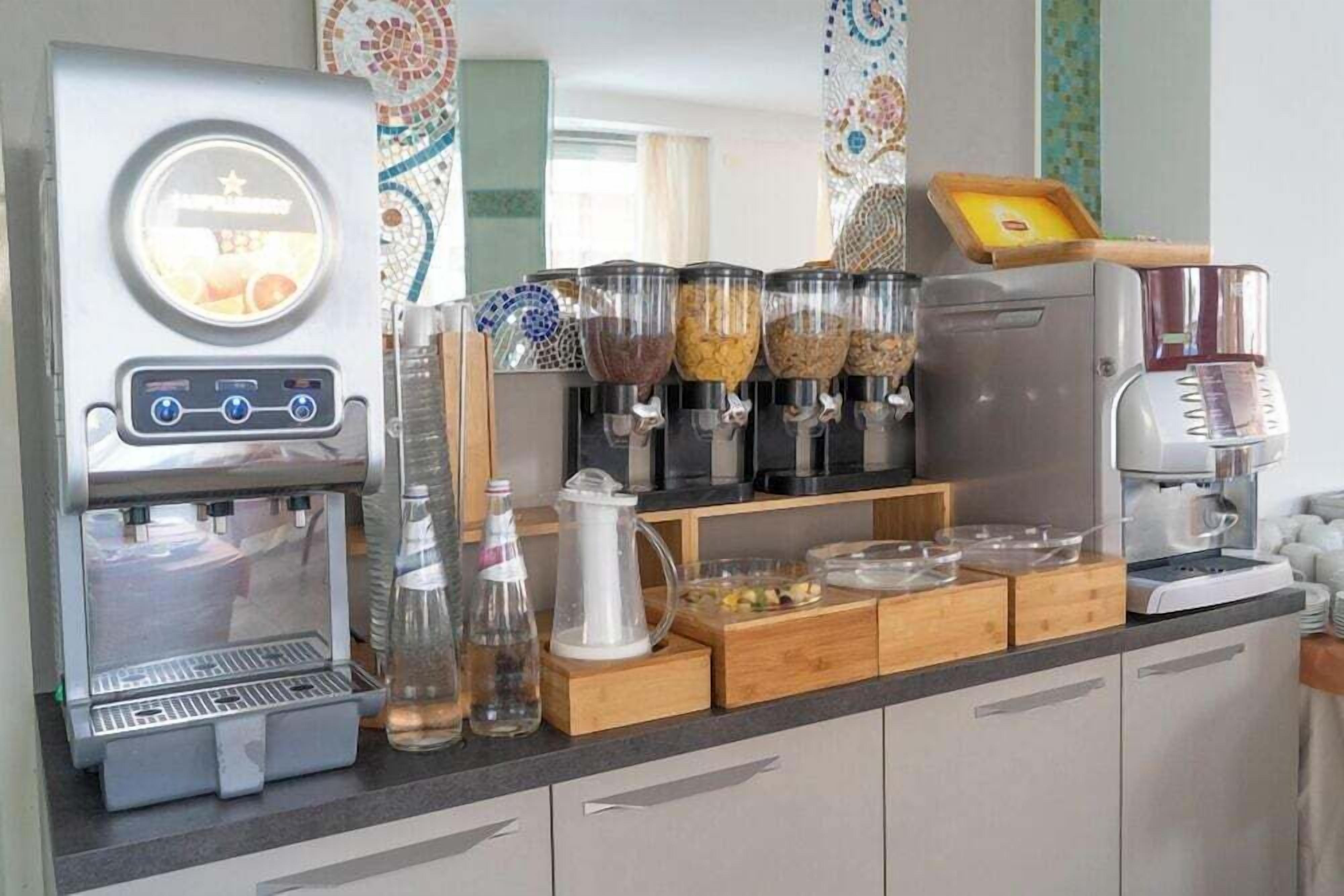 Eine Küchenzeile mit Kaffeemaschine, Wasserspender und verschiedenen Aufbewahrungsbehältern für Lebensmittel.