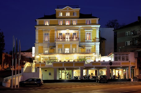 A multi-story hotel with balconies, a ground-level restaurant, and a visible entrance.