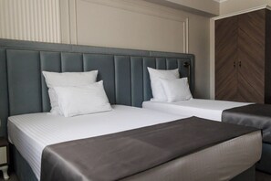 A hotel room with two beds, a large wardrobe, and a nightstand. - Anna Palace (Ruse)