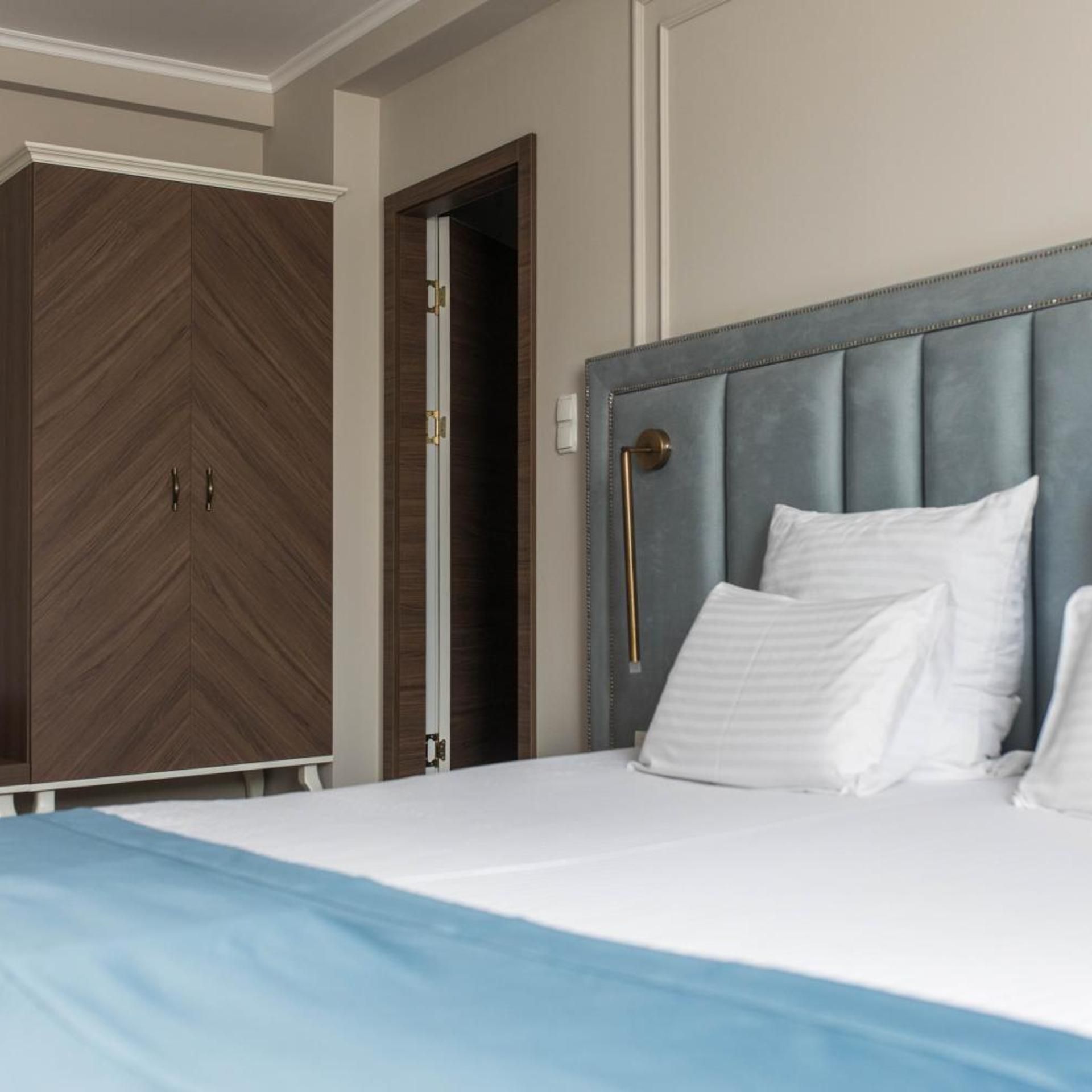 A bedroom with a bed, a wardrobe, and a door.