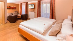 Una habitación de hotel moderna con una cama grande, un sofá y un comedor.