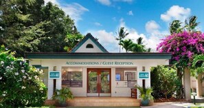 A building labeled "Accommodations / Guest Reception" with a sign for "Suite Paradise." - Kahala 914 Tropical Garden By Suite Paradise (Koloa)