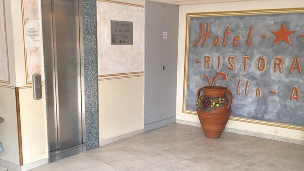A hotel lobby with a reception desk, a sign for the restaurant, and a large terracotta pot. - Hotel Villa Ada (Borgio Verezzi)