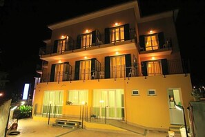 Un edificio a più piani con balconi, ampie finestre e un ingresso ben illuminato.
