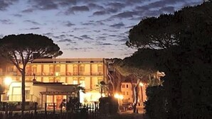 Un hotel con un patio, árboles y un edificio con ventanas iluminadas.