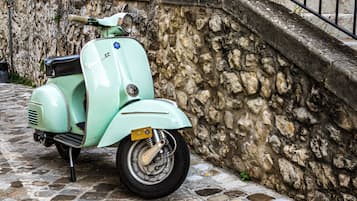 Un scooter vintage garé dans une rue pavée.